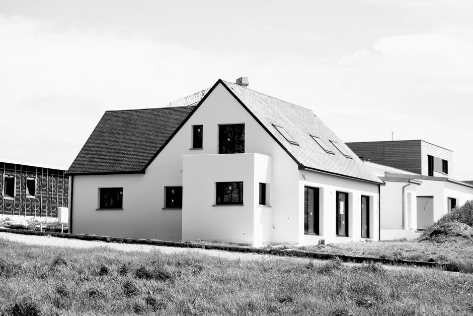 Black and white image of a modern single-family home under construction.